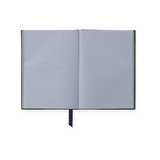 The Tiny Finch Soho notebook open to show pale blue ruled featherweight paper with gilt edges and a navy ribbon marker