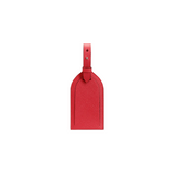 The Tiny Finch red crossgrain leather luggage tag with an adjustable strap and tonal topstitching.