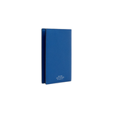 The Tiny Finch cerulean blue crossgrain leather passport cover with gold-stamped branding on the back.