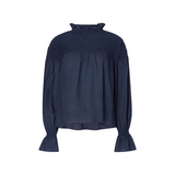 The Tiny Finch Majorelle navy blouse in Pima cotton with a hand-smocked yoke, ruffled collar, and long puff sleeves.