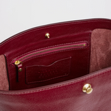 The Tiny Finch Lee Sumac bucket tote interior featuring soft vegetable tanned leather, brass hardware, and zipper pocket