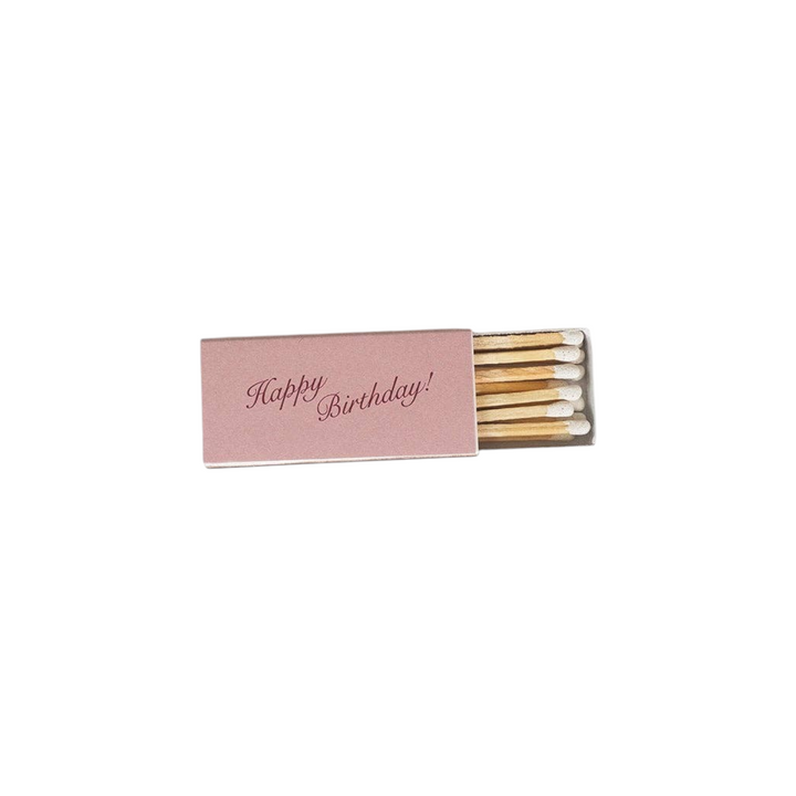 The Tiny Finch Happy Birthday matchbox in dusty pink with elegant script lettering and wooden matches inside.