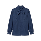The Tiny Finch Love Binetti navy cotton denim blouse with a neck tie, button front, and oversized patch pockets.