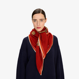 The Tiny Finch Square Jorgen red wool scarf featuring a big cat print worn by a model in a navy sweater.