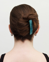 The Tiny Finch No. 3 Heirloom barrette in blue horn acetate worn in a woman's brown hair bun