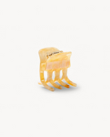 The Tiny Finch mini hair claw clip in a translucent sea shell checker pattern made from Italian bio-acetate.