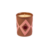 The Tiny Finch Maegen candle in a brown sand-textured ceramic pot with pink diamond and star patterns.