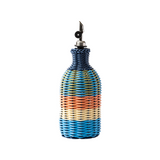 The Tiny Finch Maegen hand-woven oil pourer in peach, cream, and navy blue with a stainless steel spout.