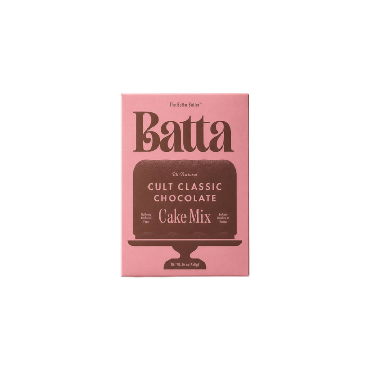 The Tiny Finch Batta Cult Classic Chocolate cake mix box in pink packaging on a matching pink background.