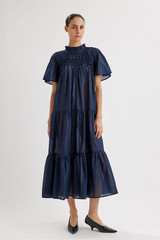 The Tiny Finch Merlette Bejart navy cotton voile midi dress with hand-smocked detailing and tiered skirt design.