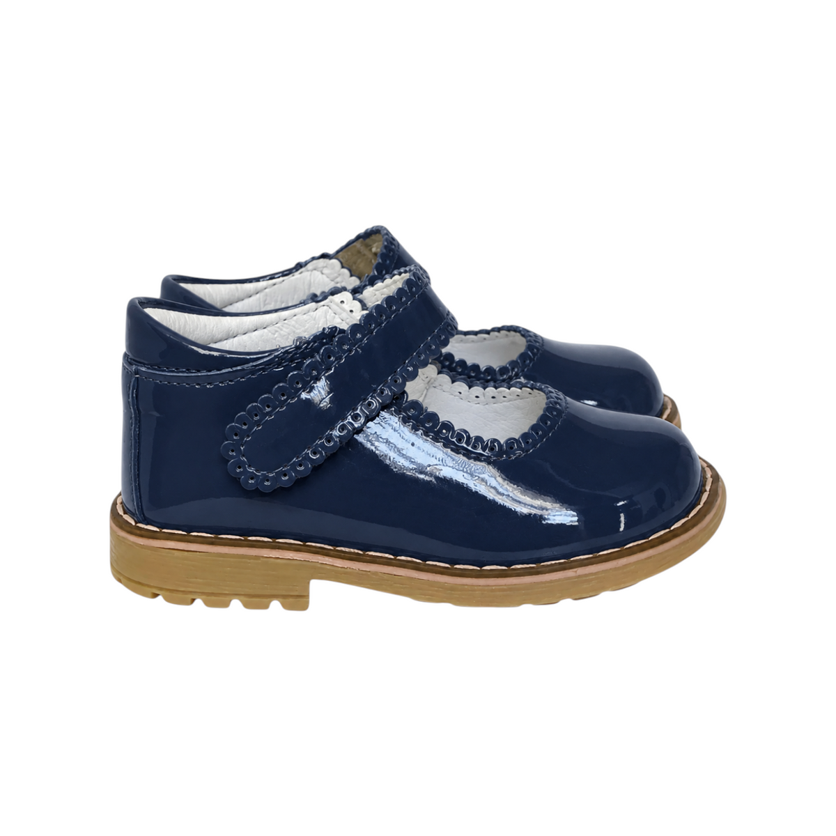 The Tiny Finch Sophie toddler shoe in navy blue patent leather with a scalloped strap and durable rubber sole.