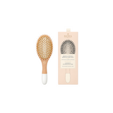 The Tiny Finch small wooden hairbrush with boar bristles and nylon pins beside its beige product packaging box.
