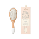 The Tiny Finch large detangling hair brush with a wooden handle and flexible nylon pins in its branded packaging.