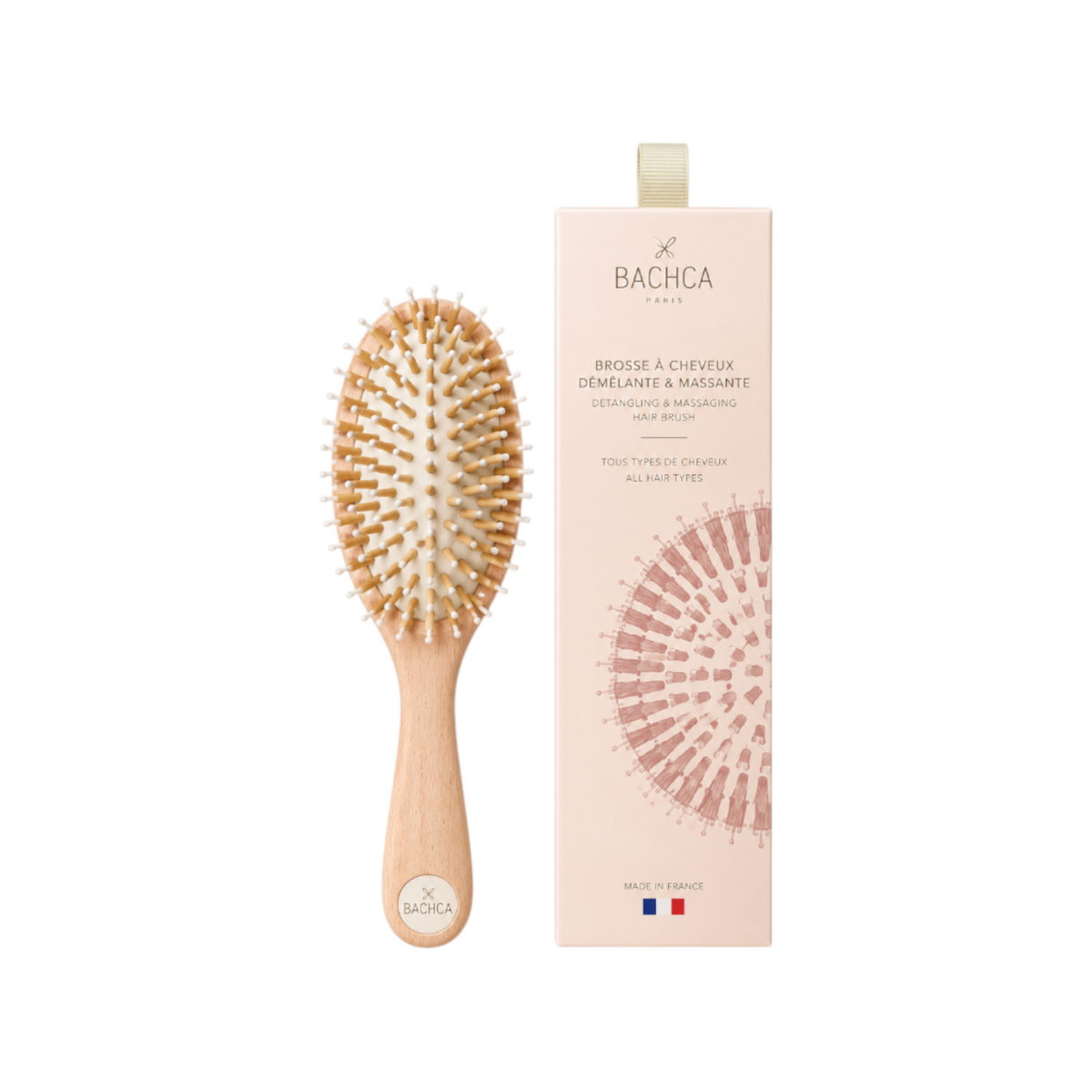 The Tiny Finch Care & Shine large hair brush with beechwood handle, boar bristles, and nylon pins next to its box.