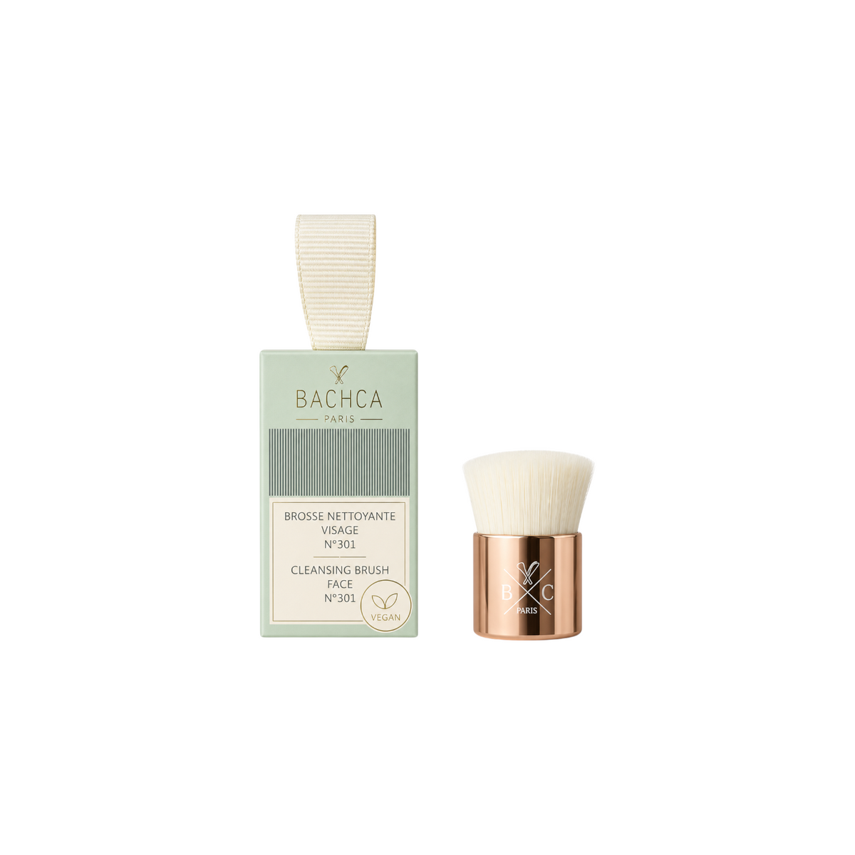 The Tiny Finch Gentle Glow facial brush with soft synthetic bristles and rose gold handle next to its green box.