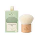 The Tiny Finch Kabuki makeup brush with soft synthetic bristles and a natural beechwood handle next to its box.