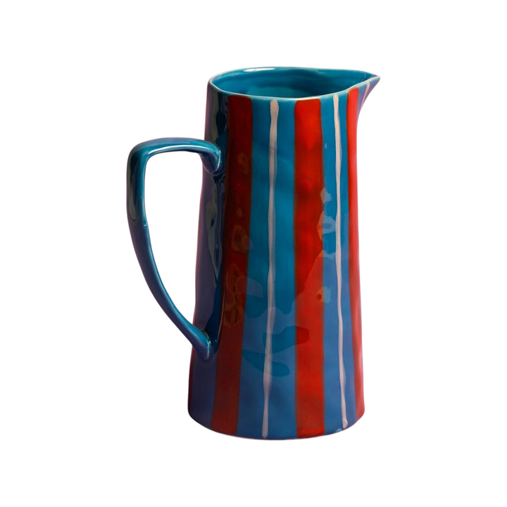 The Tiny Finch Maegen ceramic jug featuring a lapis-blue base with bold red stripes and hand-painted white details.