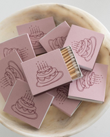 The Tiny Finch cake matchbox set in dusty pink with illustrated birthday cake designs in a marble bowl