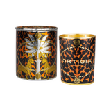 The Tiny Finch Ambra Nera candle in a decorative glass jar with a leopard print and gold foil design, next to its lid.
