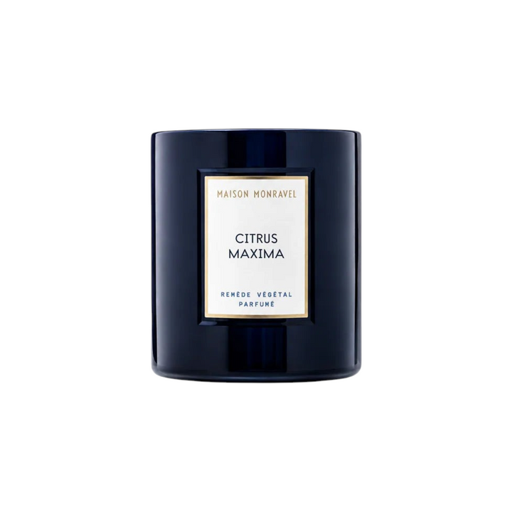 The Tiny Finch Citrus Maxima scented candle in a dark navy glass jar with a white and gold label.