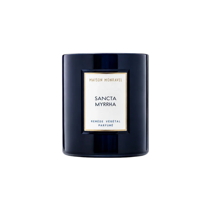 The Tiny Finch Sancta Myrrha scented candle in a dark navy glass jar with a white label and gold trim.