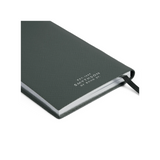 The Tiny Finch green crossgrain leather Panama pocket notebook with gilt-edged pages and a black ribbon marker.