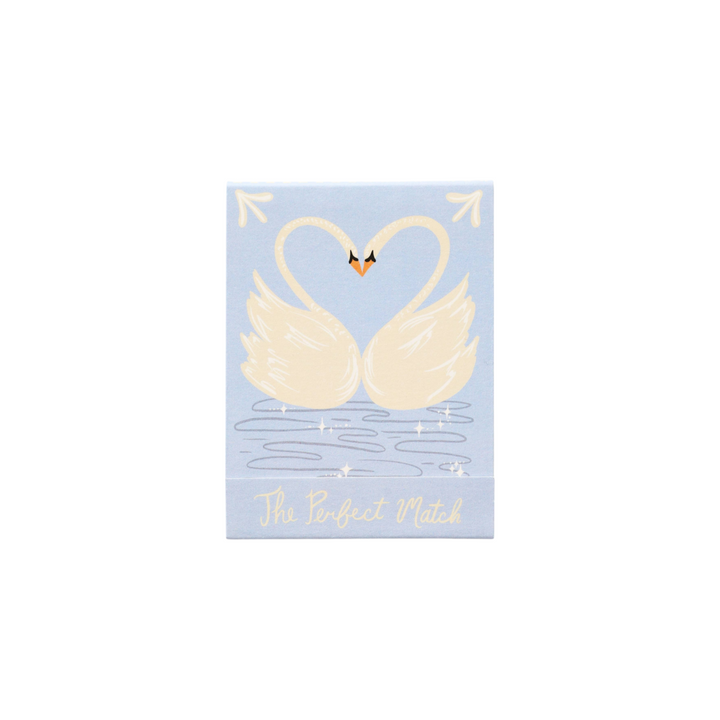 The Tiny Finch The Perfect Match matchbook featuring two white swans forming a heart on a light blue background.