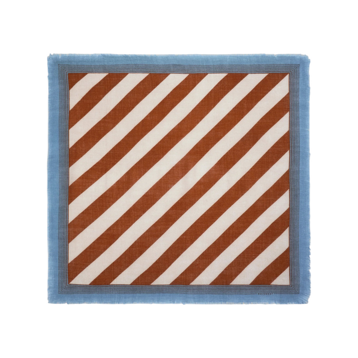 The Tiny Finch Moismont wool scarf in henna and white with diagonal stripes, blue contrast border, and fringed edges.