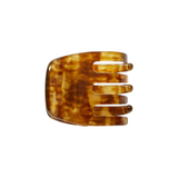 The Tiny Finch mini hair claw clip in a brown walnut Italian bio-acetate with a tortoiseshell pattern.