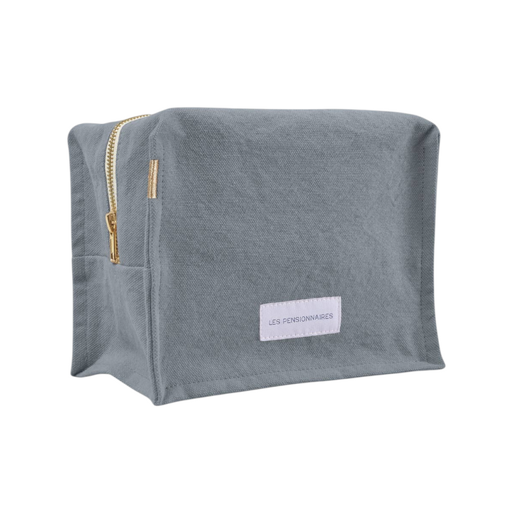 The Tiny Finch Horizon Blue cube toiletry bag in organic cotton canvas with a gold zipper and interior pocket.