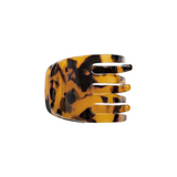 The Tiny Finch mini hair claw clip in a classic brown and black tortoise shell pattern made from Italian bio-acetate.