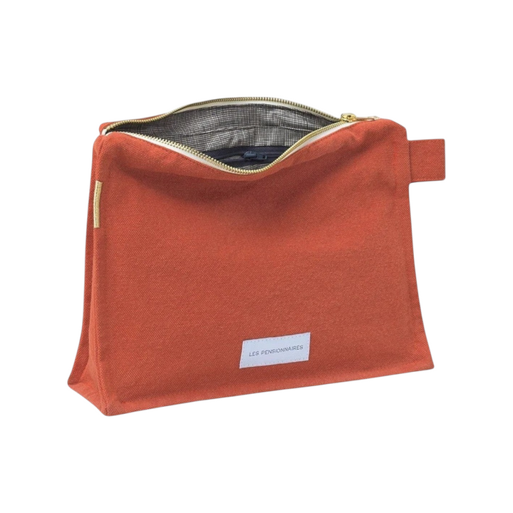 The Tiny Finch Les Pensionnaires orange organic cotton canvas toiletry bag with a checkered lining and gold zipper.