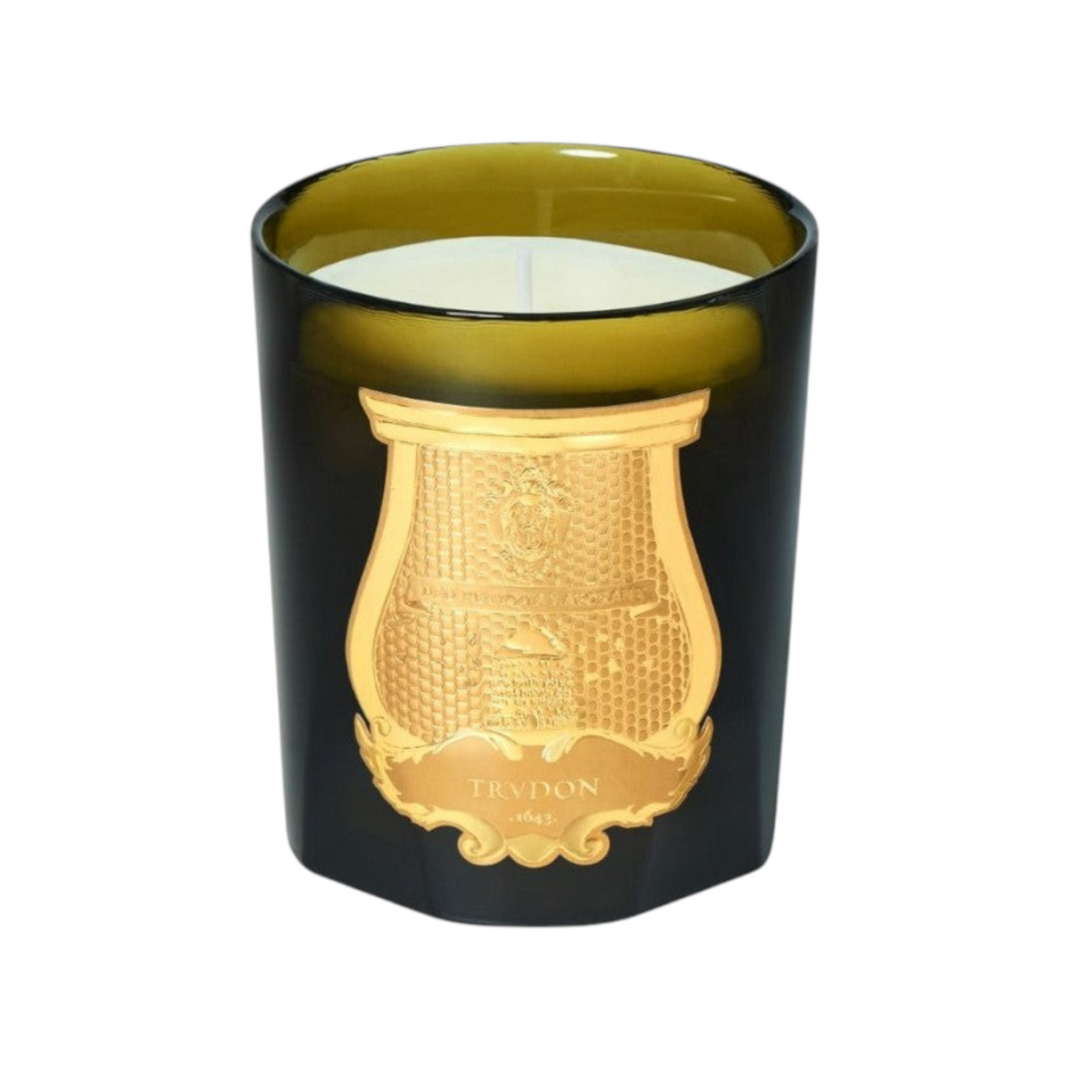 The Tiny Finch Madeleine candle in a dark green glass vessel with a gold embossed crest label.