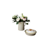 The Tiny Finch handmade stoneware pitcher filled with pink ranunculus flowers on a rustic wooden dining table