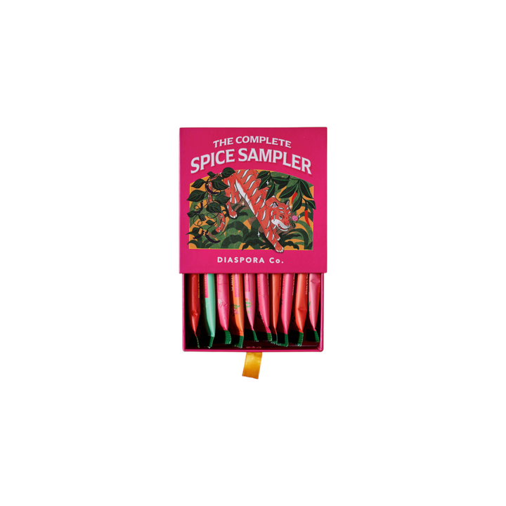 The Tiny Finch Spice Sampler box featuring a vibrant pink design with a tiger illustration and 10 colorful spice sachets.