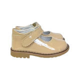The Tiny Finch Sophie toddler shoe in oat vegan patent leather with a scalloped strap and durable rubber sole
