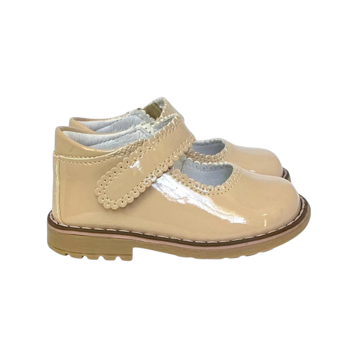 The Tiny Finch Sophie toddler shoe in oat vegan patent leather with a scalloped strap and durable rubber sole