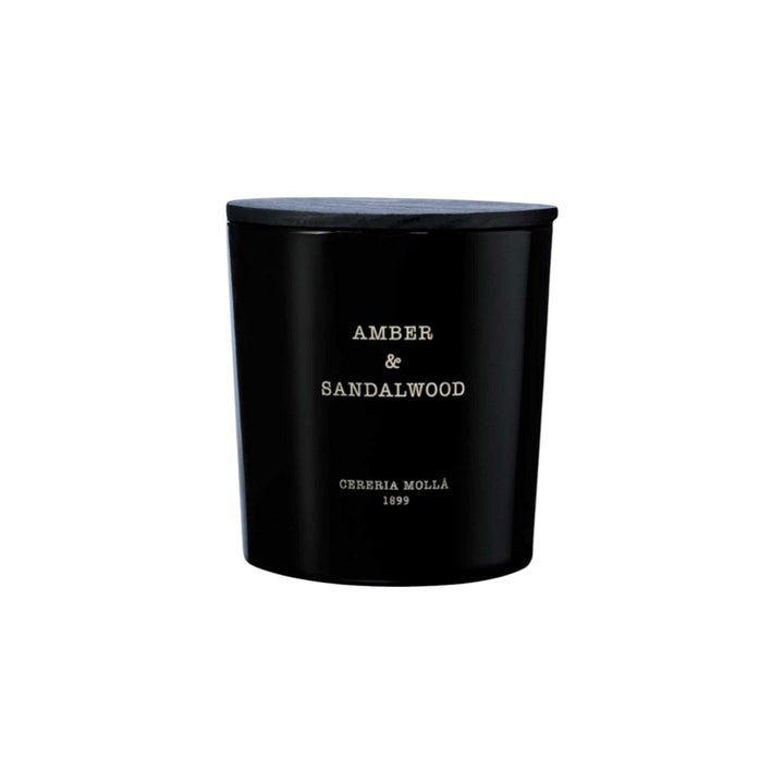 The Tiny Finch Amber & Sandalwood 3-wick candle in a black hand-painted glass vase with a matching wooden lid.