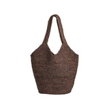 The Tiny Finch Bembien Playa tote bag in brown woven raffia with a flexible unlined design and sturdy leather base.