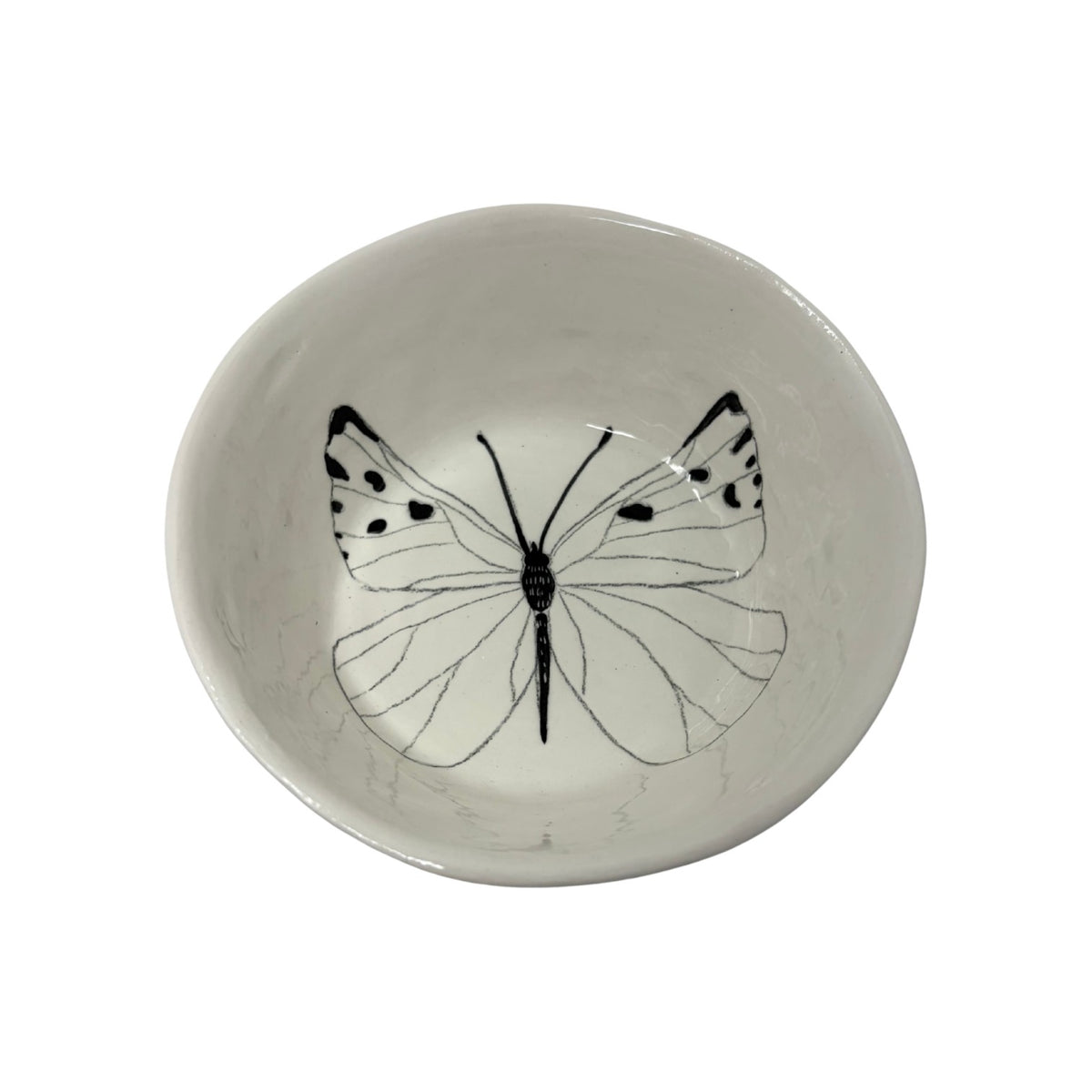 The Tiny Finch white ceramic snack bowl featuring a delicate black butterfly illustration on the interior base.