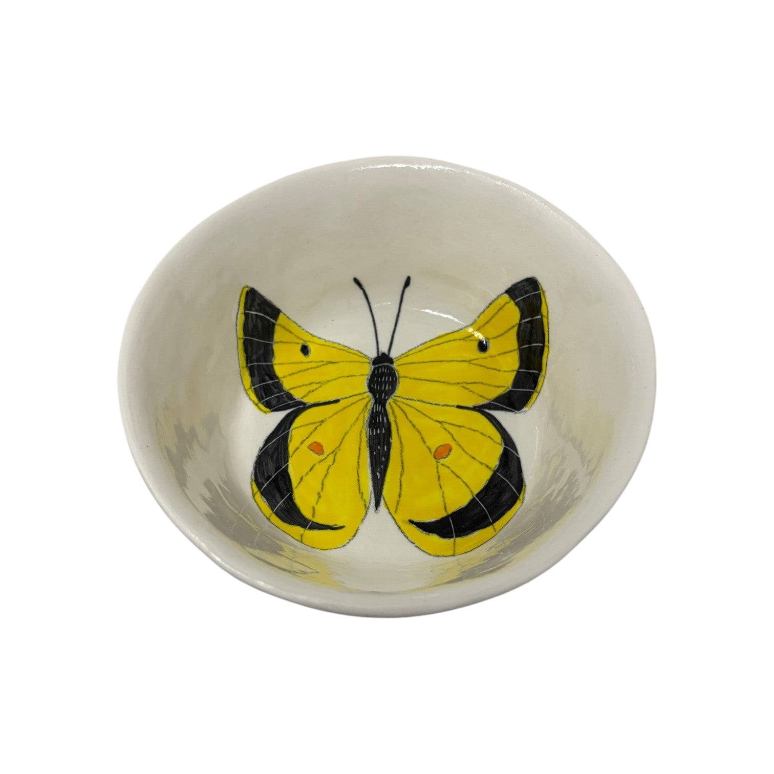 The Tiny Finch ceramic snack bowl featuring a hand-painted yellow and black butterfly design on a cream background.