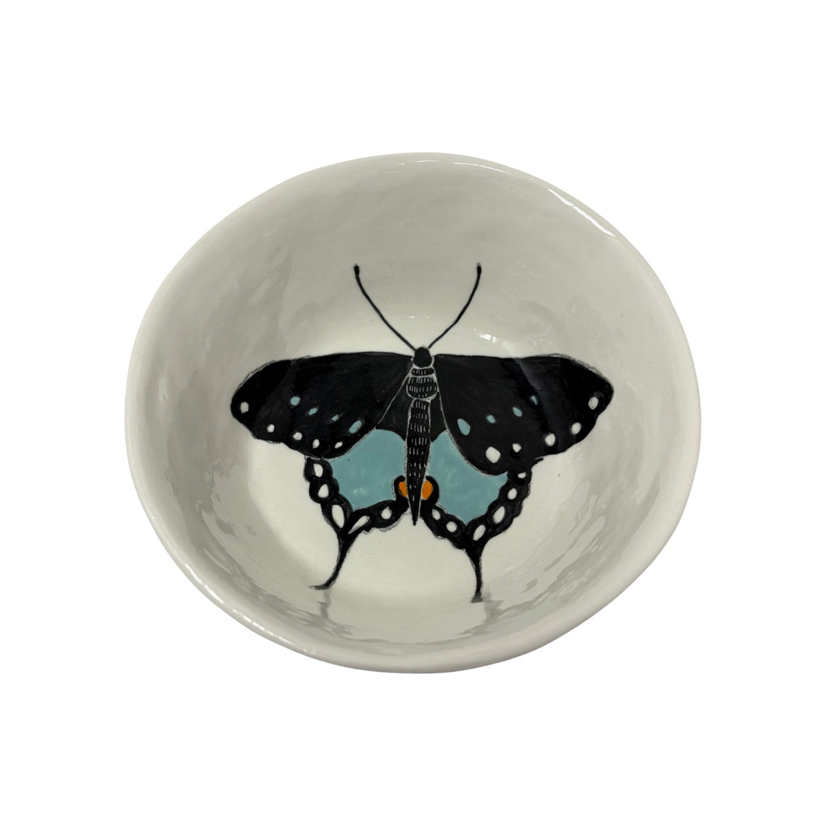 The Tiny Finch ceramic snack bowl featuring a hand-painted black and blue butterfly design on a white background.