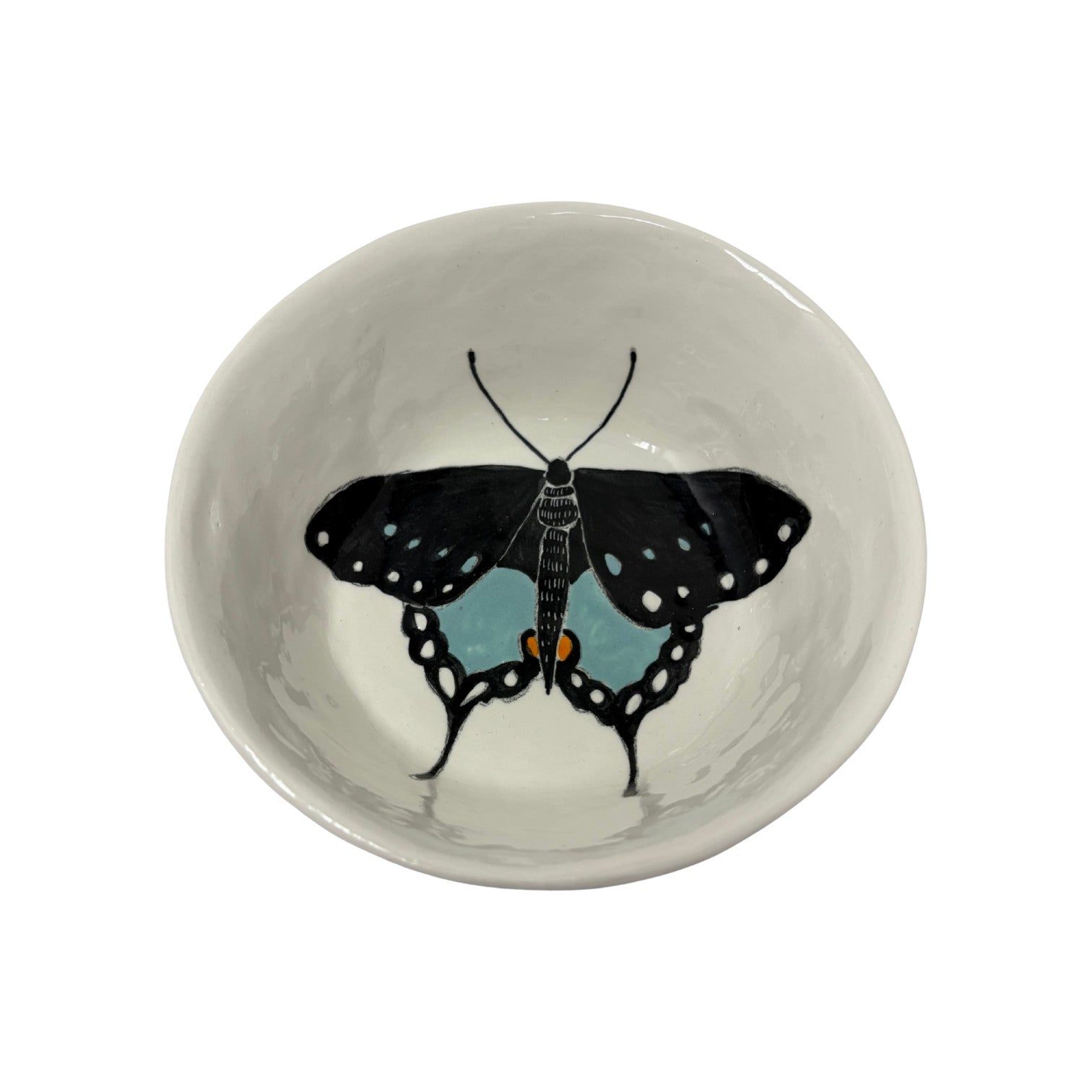 The Tiny Finch ceramic snack bowl featuring a hand-painted black and blue butterfly design on a white background.