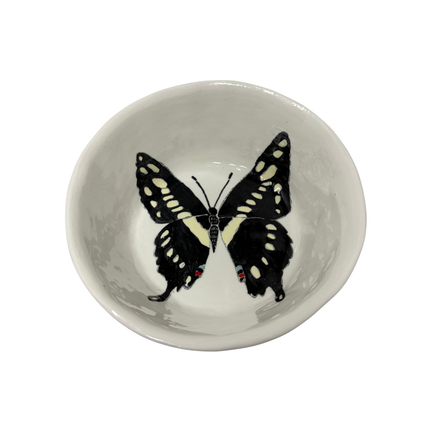The Tiny Finch snack bowl featuring a hand-painted black and white butterfly design on a white ceramic surface.