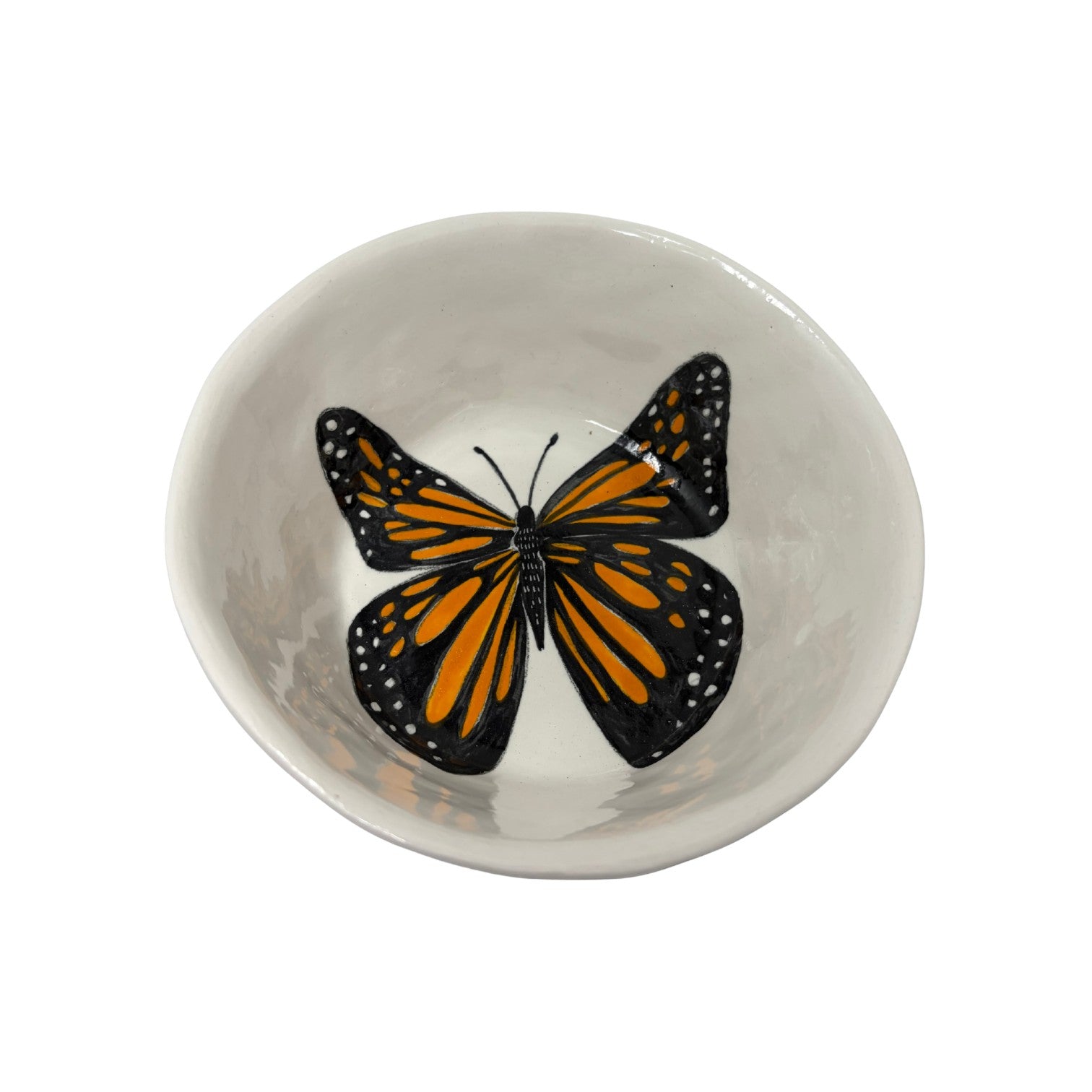 The Tiny Finch snack bowl featuring a hand-painted orange and black monarch butterfly on a white ceramic surface.