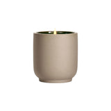 The Tiny Finch Cece candle in a beige kiln-fired ceramic vessel with a green interior and a lit organic cotton wick.