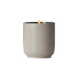 The Tiny Finch Cocomoi soy wax candle in a speckled grey kiln-fired ceramic vessel with a lit organic cotton wick.