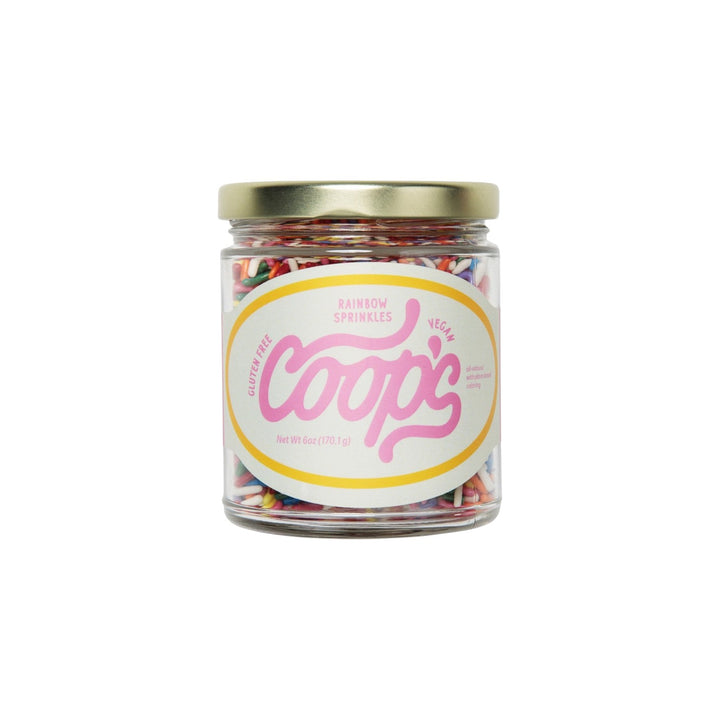 The Tiny Finch Coop's rainbow sprinkles in a 6 oz glass jar with a gold lid and natural plant-based colors.