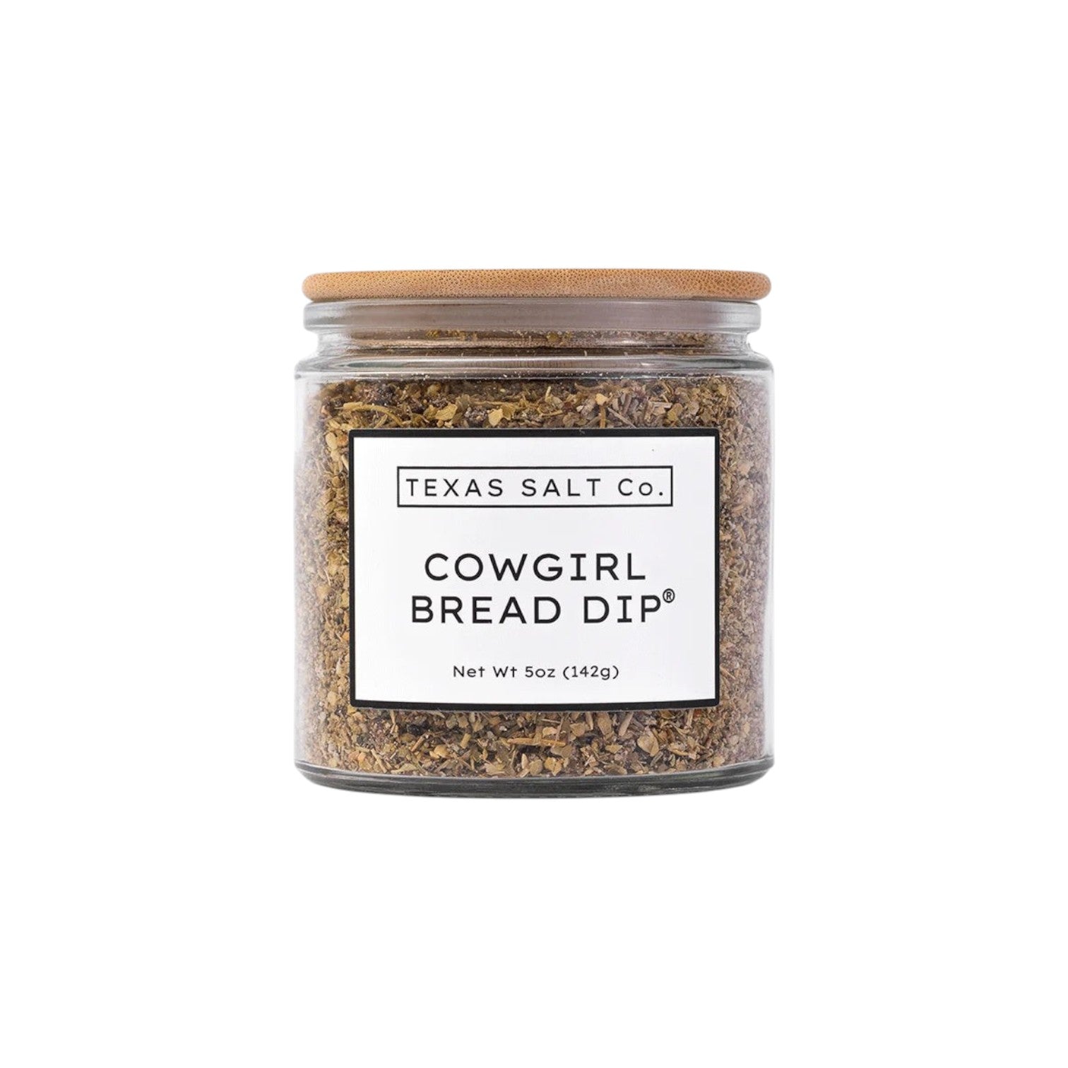 The Tiny Finch Cowgirl Bread Dip seasoning mix in a glass jar with a bamboo lid, featuring sun-dried tomato and herbs.