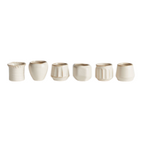 The Tiny Finch Dezie mini pots in a set of six, featuring various cream-colored ceramic shapes and textures.